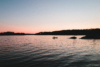 lone canoe on a lake during sunset