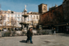 Two gentlemen walking across a public square in Granada