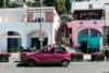 a pink Fiat Cinquequento in front of a pink house on Capri